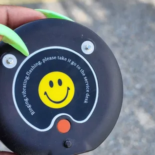 a person holding a black and yellow smiley face device