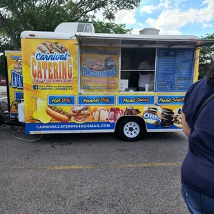 a woman standing in front of a food truck