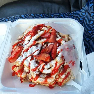 strawberries and powdered sugar on a waffle