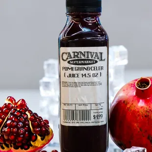 a bottle of pomegranate next to a pomegranate