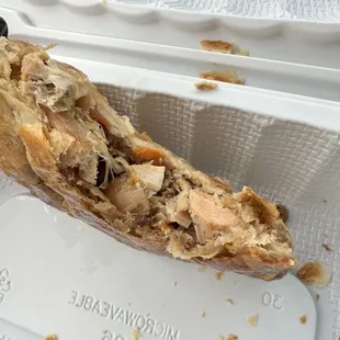 a half eaten sandwich in a styrofoam container