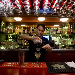 a bartender pouring a martini