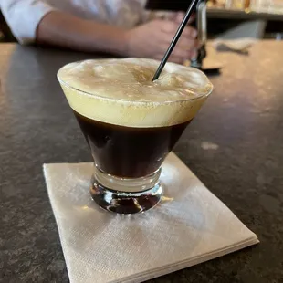 a glass of coffee on a napkin