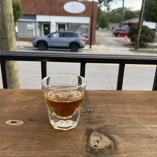 a shot of a drink on a wooden table