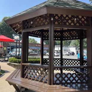 a wooden gazebo in a park