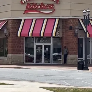 Front of building, guy who was opening the door for customers asking for money