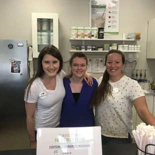 three women standing behind a counter