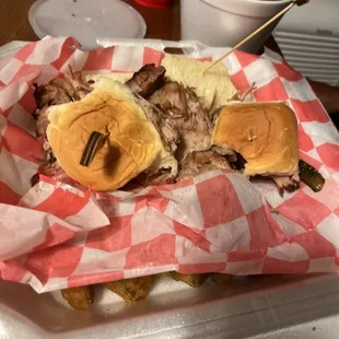 Pork slider with okra under the red paper and collard greens in the white bowl