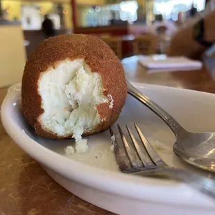 a half eaten donut on a plate with a fork
