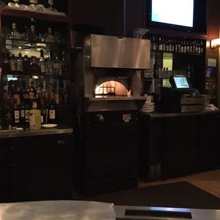 In addition to a full restaurant, a pizza oven behind the bar.