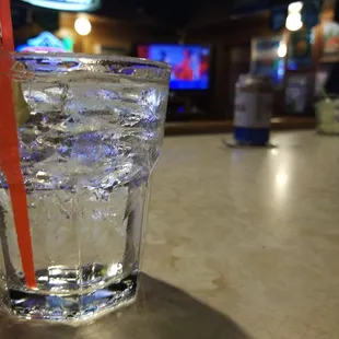 a glass of water with ice and a straw