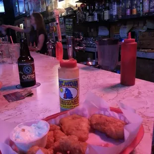 a tray of fried fish and a bottle of beer