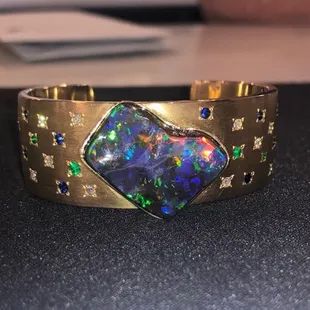 Scott made a custom 18k opal, sapphire, emerald, and diamond cuff for a customer