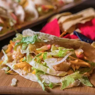 two tacos on a cutting board