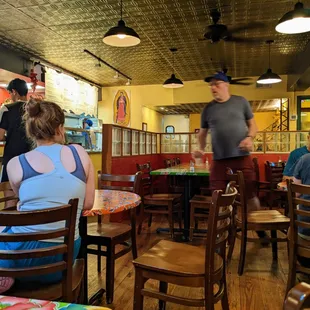 Inside. Dining room. Facing towards kitchen door. Fast-casual restaurant setup.