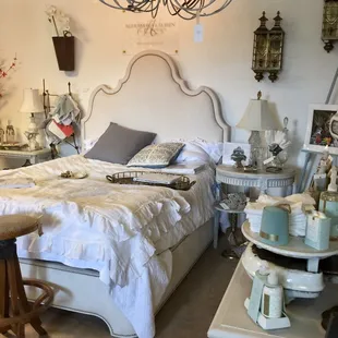 a bed with white linen and a chandelier