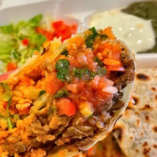 a hand holding a burrito