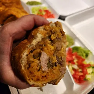 a hand holding a burrito