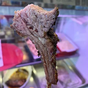 a hand holding a piece of meat