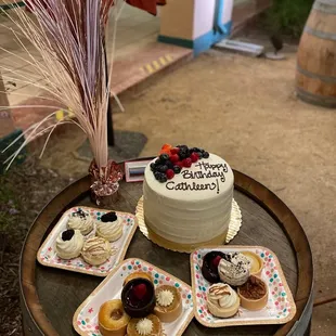 a cake and pastries on a barrel