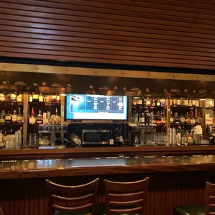 a bar with a television and bar stools