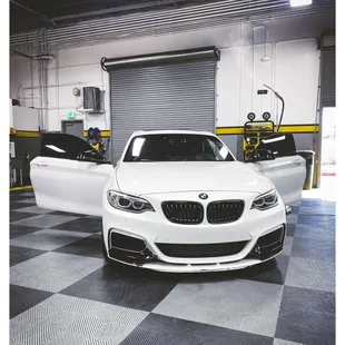 a white bmw car in a garage