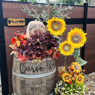 a barrel with sunflowers and a pumpkin