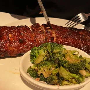 a plate of ribs and broccoli