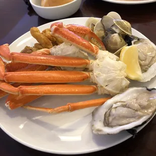 a plate of crab legs, clams, and oysters