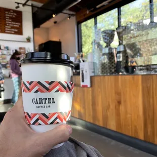 a hand holding a cup of coffee