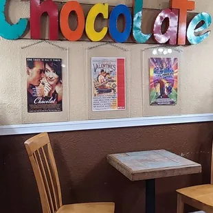 a table and chairs in front of a sign that says eat chocolate