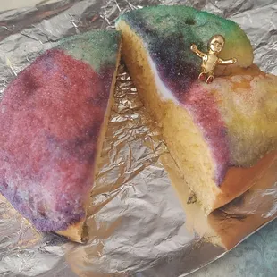a rainbow cake with a gold figurine on top