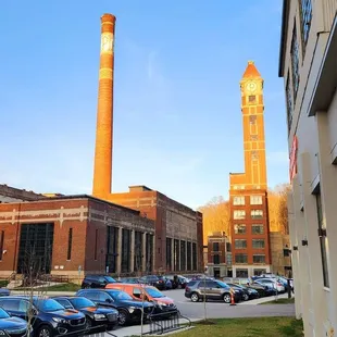 a parking lot with cars in front of a factory