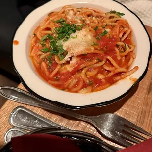 a plate of spaghetti with sauce and parmesan cheese