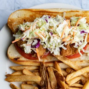 a chicken sandwich with coleslaw and fries