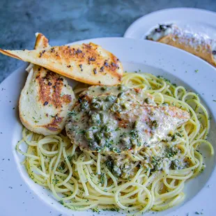 a plate of spaghetti with meat and bread