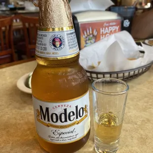 a bottle of modelo beer next to a glass