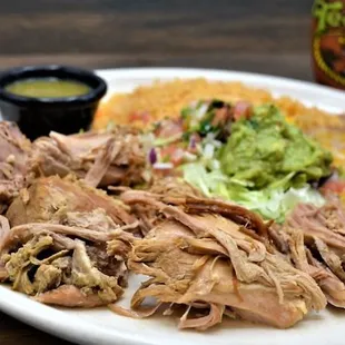 a plate of pulled pork, rice, and guacamole
