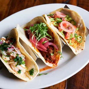 three tacos on a white plate