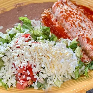 Chimichanga with red sauce, beans and salad.
