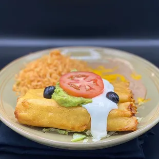 Flautas topped with guacamole and sour cream.