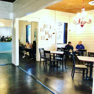 people sitting at tables in a cafe
