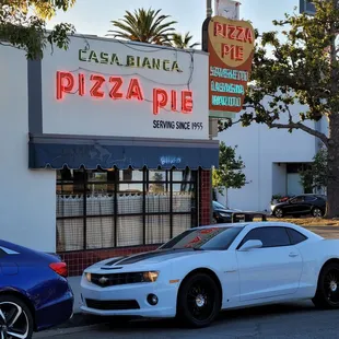 a white car parked in front of a restaurant