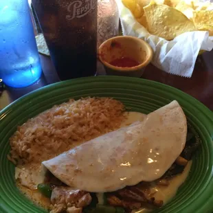 Chicken fajita quesadilla with rice and cheese dip on top.