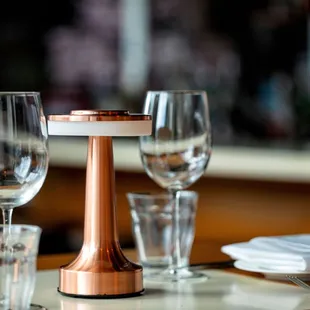 a table setting with wine glasses and napkins