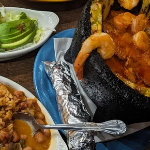 a plate of shrimp and rice with a side of avocado