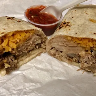 A burrito of pork carnitas, beans, rice, onions &amp;  cilantro. With salsa. Very nice.