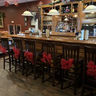 a row of wooden chairs with red bows tied to them