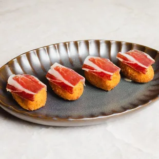 four pieces of meat on a plate