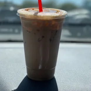 a drink in a plastic cup with a red straw